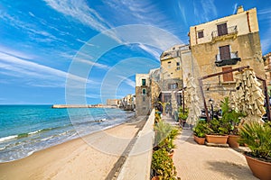 Sandy beach near clear blue sea in Cefalu, Sicily, Italy