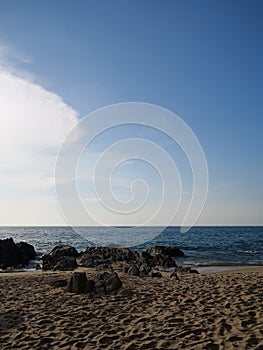 Sandy beach over sea and blue summer sky background