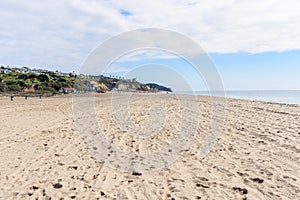 Sandy beach overlooked by clifftop houses along the coast of California