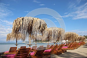 Sandy Beach With Palm Leaves Umbrella And Sunny