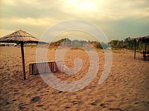 Sandy beach, parasol and sunbad