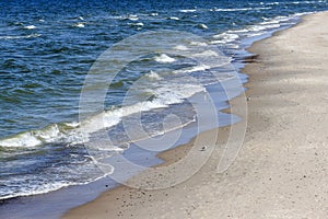 Sandy beach with pebbles on the sand in a sunny day. Baltic Sea