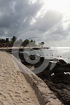 Sandy beach,rocks and palmtrees during rainy season photo