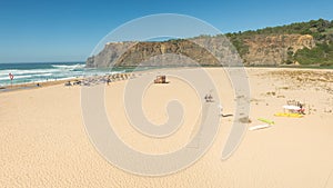 a sandy beach with rocky cliffs on the background,Praia de Odeceixe, Portugal
