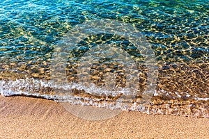 Sandy beach of sea. Transparent turquoise water, soft wave, sunlight reflecting on sea bottom