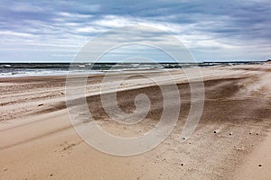 Sandy beach on stormy day by the sea