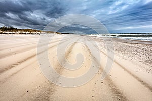 Sandy beach on stormy day by the sea