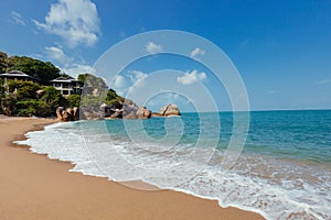 Sandy beach stretching along the ocean, with houses visible in the background