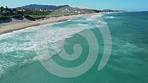 Sandy beach with waves in Brazil. Aerial view of Campeche beach, Florianopolis