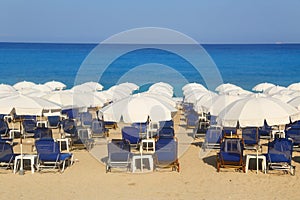 Sandy beach with white parasols and sunbeds