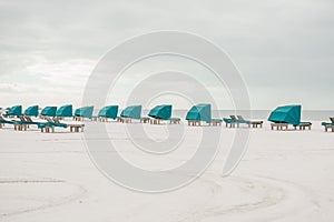 Sandy beach with white sand and rows of chaise lounges with canopies for relaxation. Coast of the Atlantic Ocean. Florida. USA. Ma