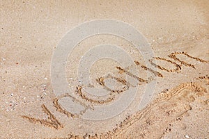 Sandy beach with written word Vacation on sunny day.