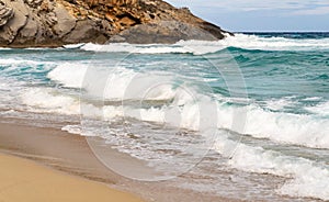 Sandy coast with rocks and waves