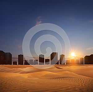 Sandy desert and silhouette of city on horizon at sunset