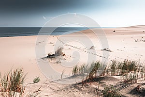 Sandy dunes on the shore of sea bay. Footprints on the sand