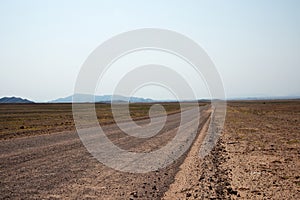 Sandy empty road crossing the namibian desert. Namibia