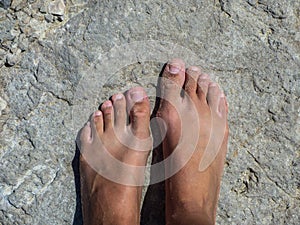 Sandy feet on a rock