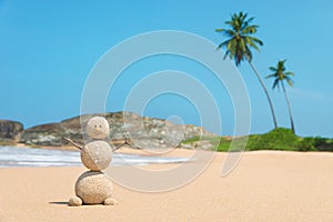 Sandy man at ocean beach against blue sky and palms