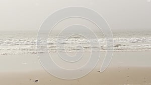 Sandy misty beach California USA. Pacific ocean coast, dense fog on sea shore. Waves in brume haze.