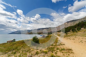 Sandy path in Peschanaya bay at Baikal lake in summer on a sunny day with clouds