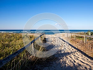 Sandy pathway entrance to the beach with wooden rails Gold Coast Australia