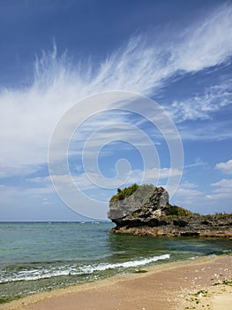 Sandy and Rocky shorline in Okinawa Japan with white puffy clouds