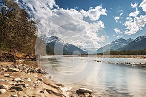 Sandy and stony river bank and blue sky