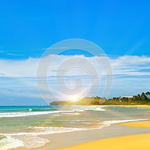 Sandy tropical beach, blue ocean water and bright sun rise