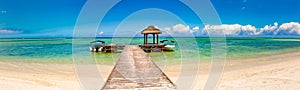 Sandy tropical beach. Jetty on the foreground. Panorama