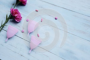 Sanitary cups with pills and roses on the table