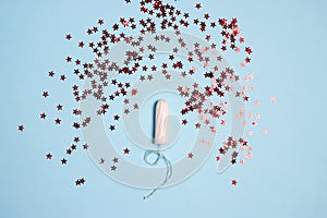 Sanitary female tampons with red glitter stars on blue background