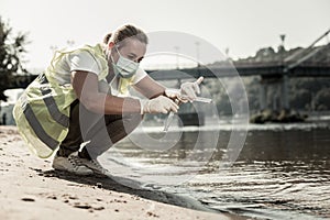Sanitary inspector holding test tubes while checking water contamination level photo
