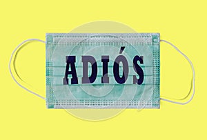 Sanitary mask with the illustrated Spanish word "Adios" meaning goodbye