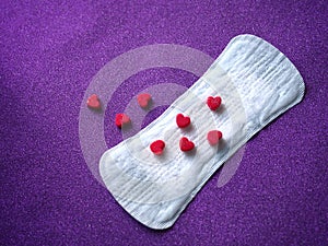 Sanitary napkin and red hearts background