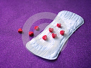 Sanitary napkin and red hearts background