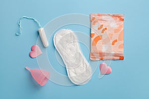 sanitary pads, reusable silicon cup and tampon on blue, menstruation woman