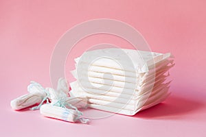 Sanitary pads and tampons on pink background photo