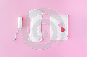 Sanitary swab and pads on a pink background.
