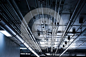 Sanitary system pipes and electrical cables installed under flat slab reinforced concrete structure in building.Ventilation pipes