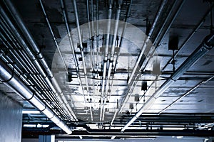 Sanitary system pipes and electrical cables installed under flat slab reinforced concrete structure in building.Ventilation pipes