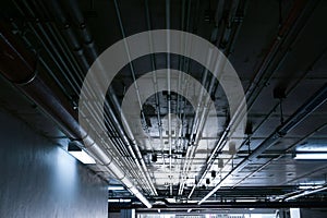 Sanitary system pipes and electrical cables installed under flat slab reinforced concrete structure in building.Ventilation pipes