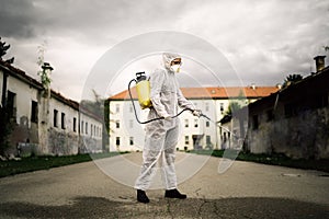 Sanitation service worker disinfecting public space with disinfectant spray.Street disinfection.Coronavirus COVID-19 pandemic