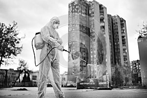 Sanitation service worker disinfecting public space with disinfectant spray.Street disinfection.Coronavirus COVID-19 pandemic photo