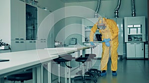 Sanitation worker is cleaning table surface in the quantorium