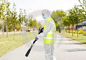 Sanitation worker in hazmat with pressure washer