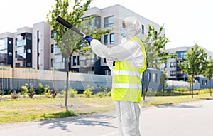 Sanitation worker in hazmat with pressure washer