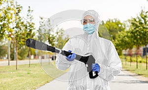 Sanitation worker in hazmat with pressure washer