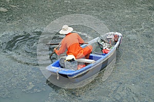 Sanitation workers clean up the rubbish in the river