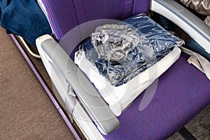 Sanitized and sealed wool blanket in plastic bag provided to passengers to keep warm and comfortable during flight