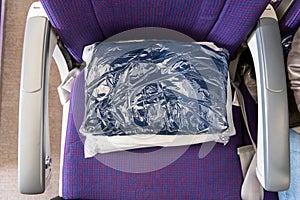 Sanitized and sealed wool blanket in plastic bag provided to passengers to keep warm and comfortable during flight